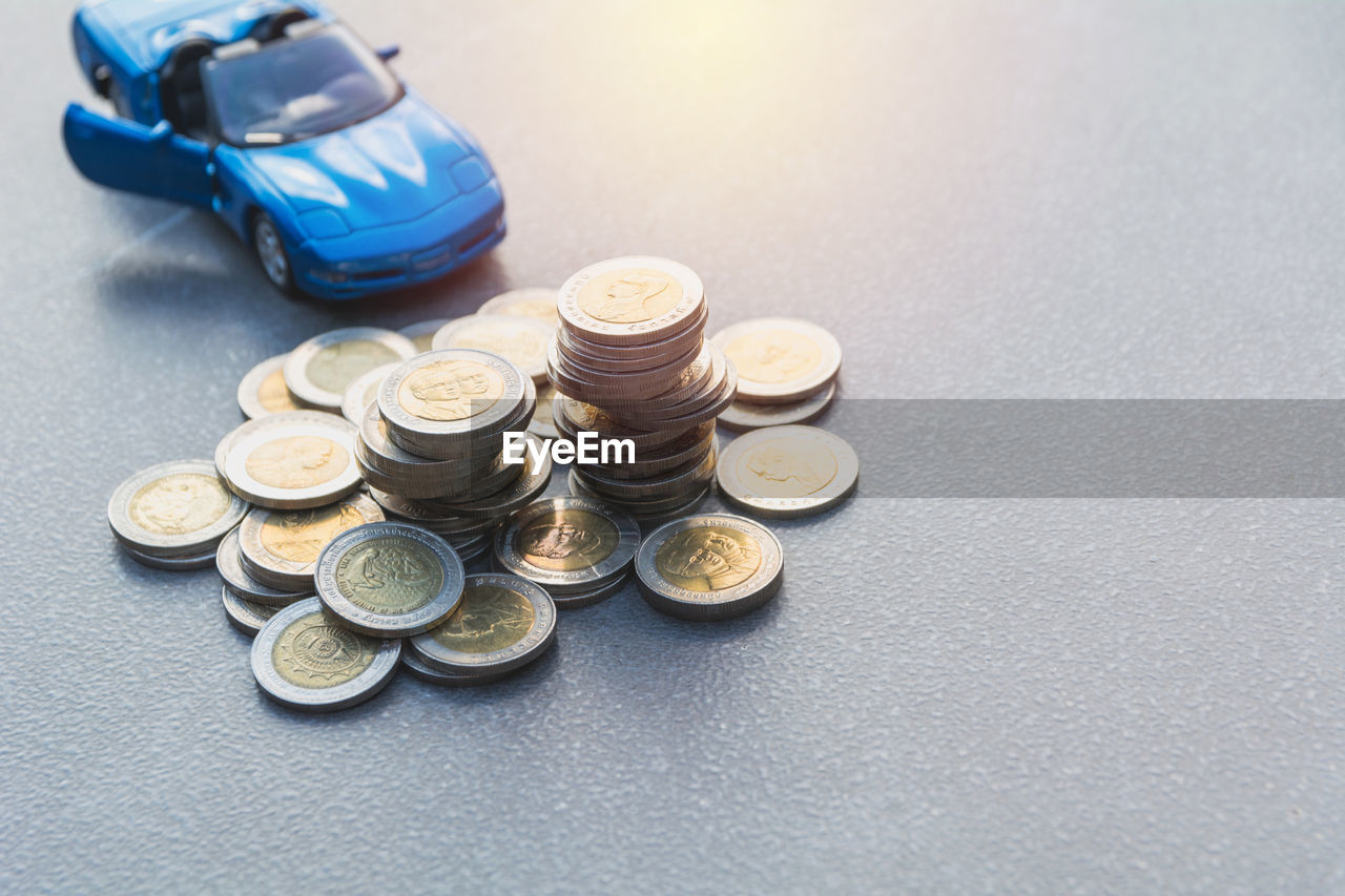 High angle view of coins with toy car on table