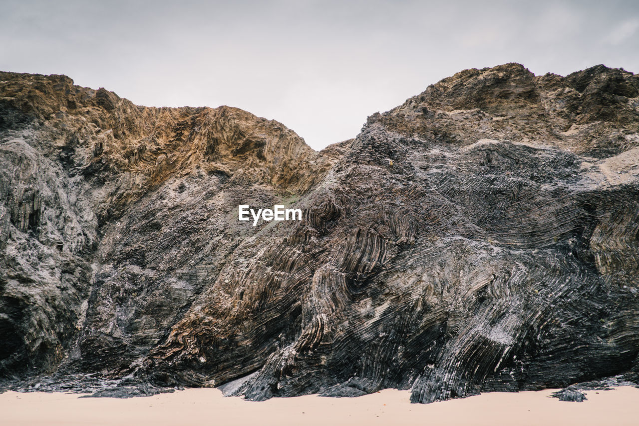 Close-up of rock formation against sky