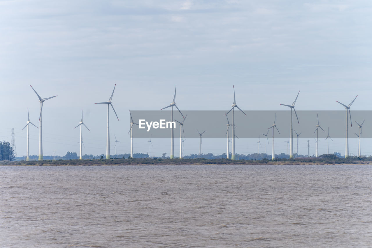 Wind turbines on land against sky