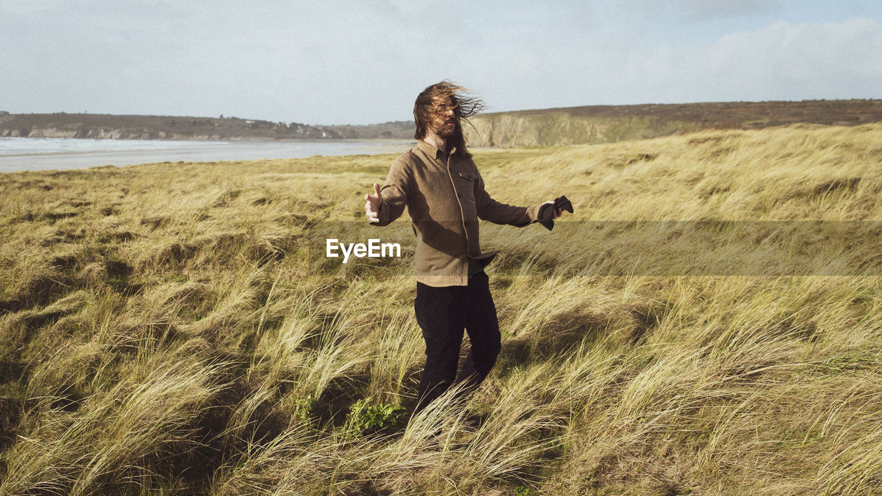 Full length of woman standing on land against sky