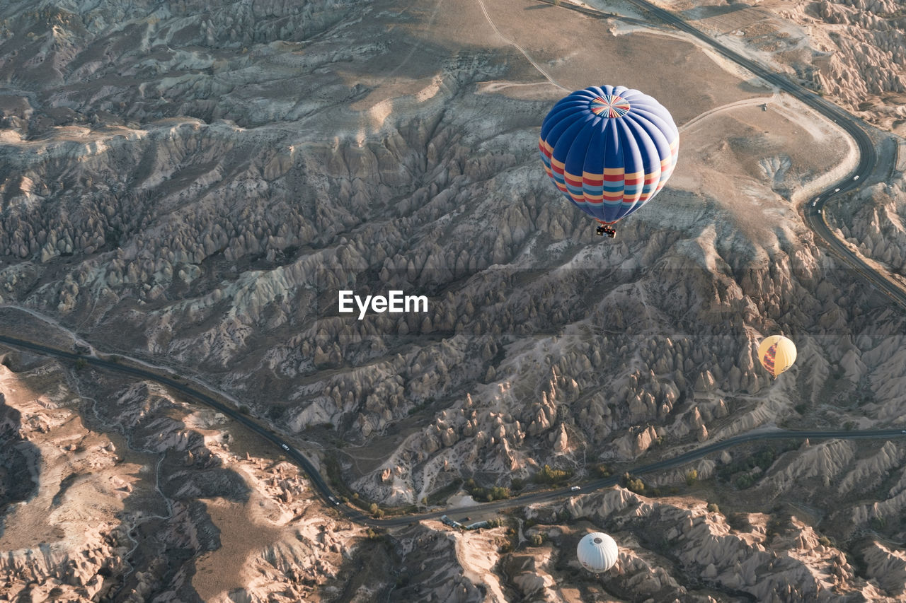 HIGH ANGLE VIEW OF HOT AIR BALLOONS FLYING OVER ROCKS