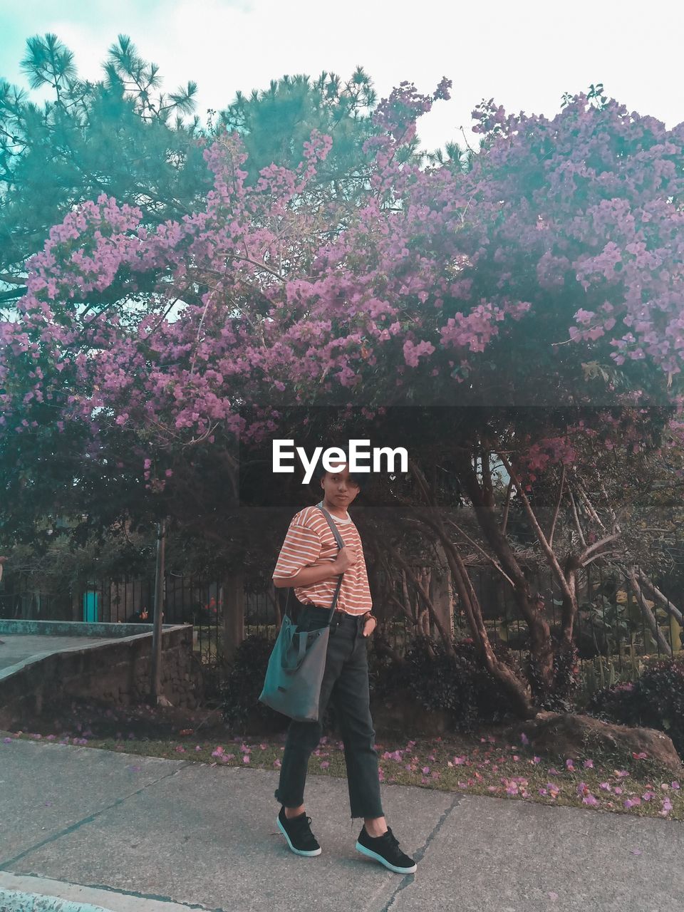 PORTRAIT OF WOMAN STANDING BY PINK TREE