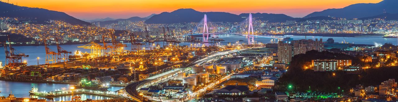 Panoramic view of illuminated dock and bridge in city