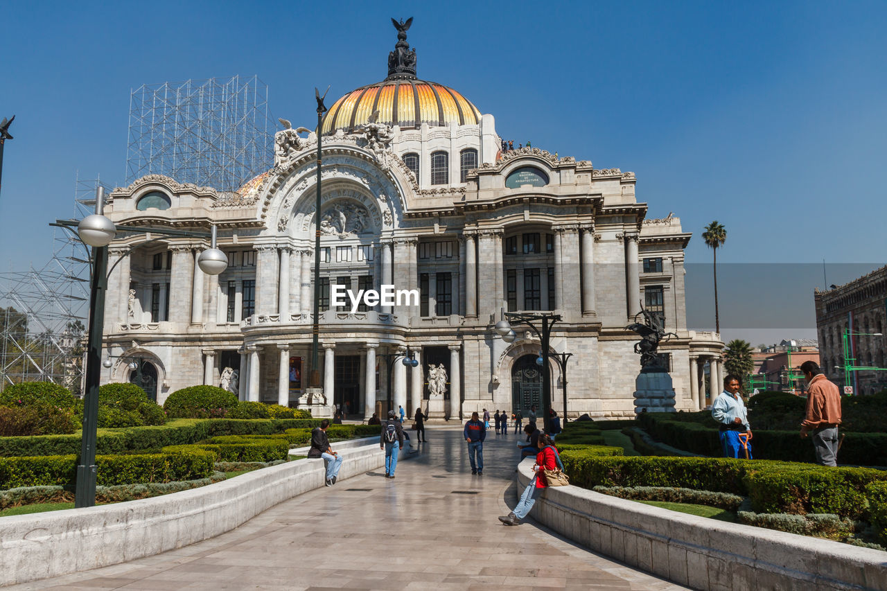 PEOPLE IN FRONT OF HISTORICAL BUILDING AGAINST SKY