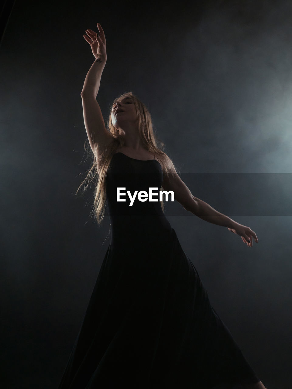 Woman dancing against black background