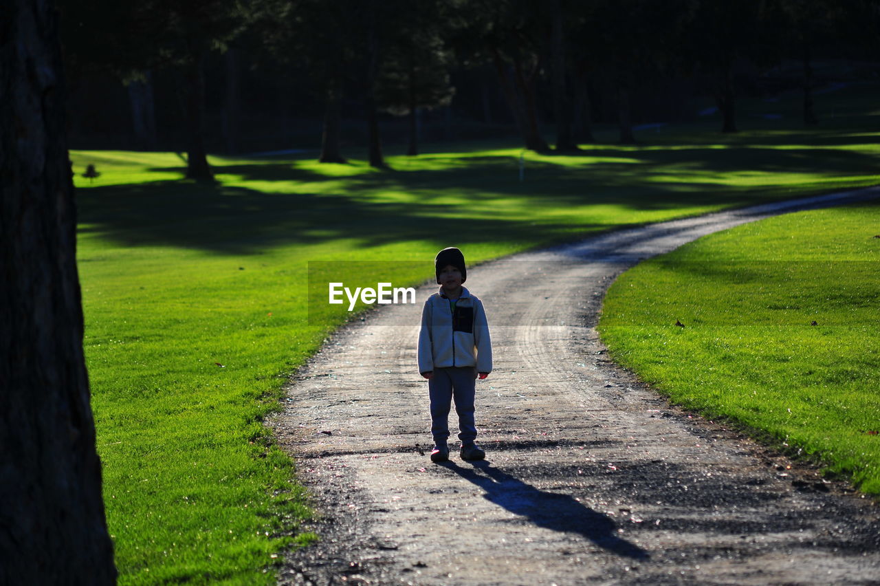 Boy standing on path in park