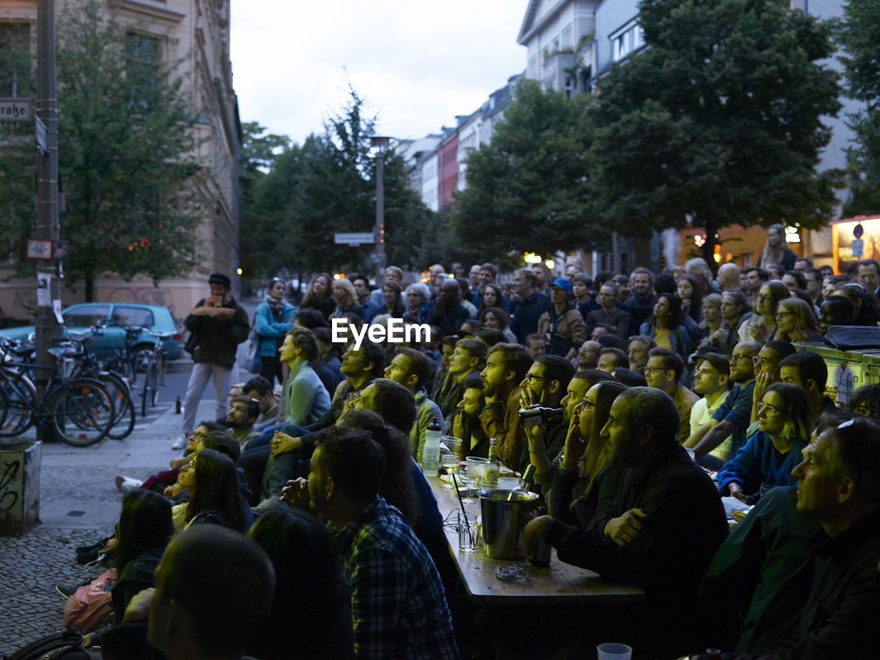 PEOPLE SITTING ON STREET IN CITY