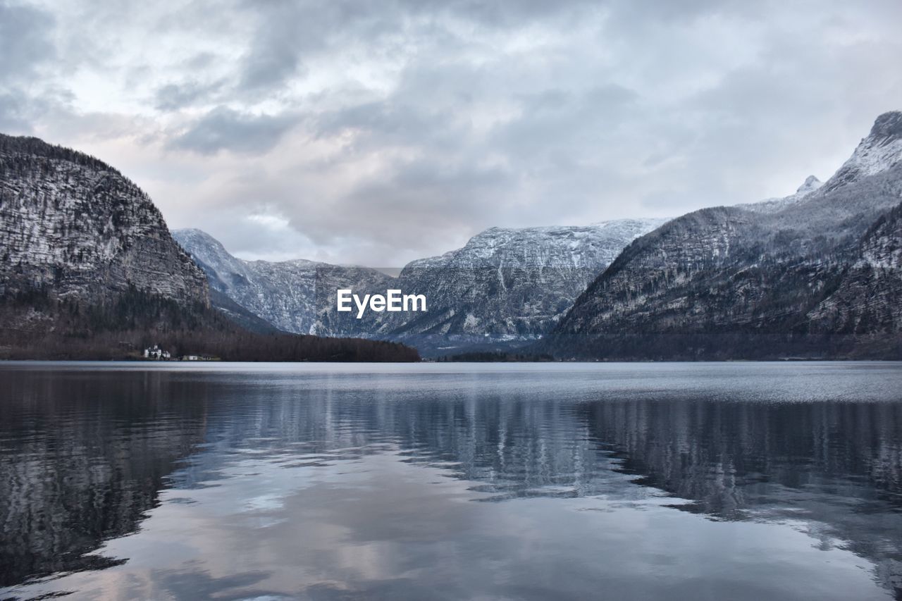 Scenic view of lake by mountains against sky