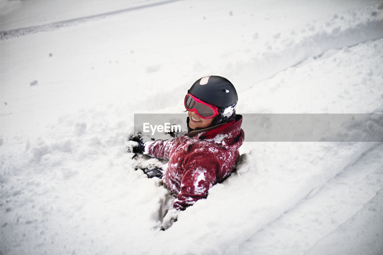 Portrait of woman sitting in snow field