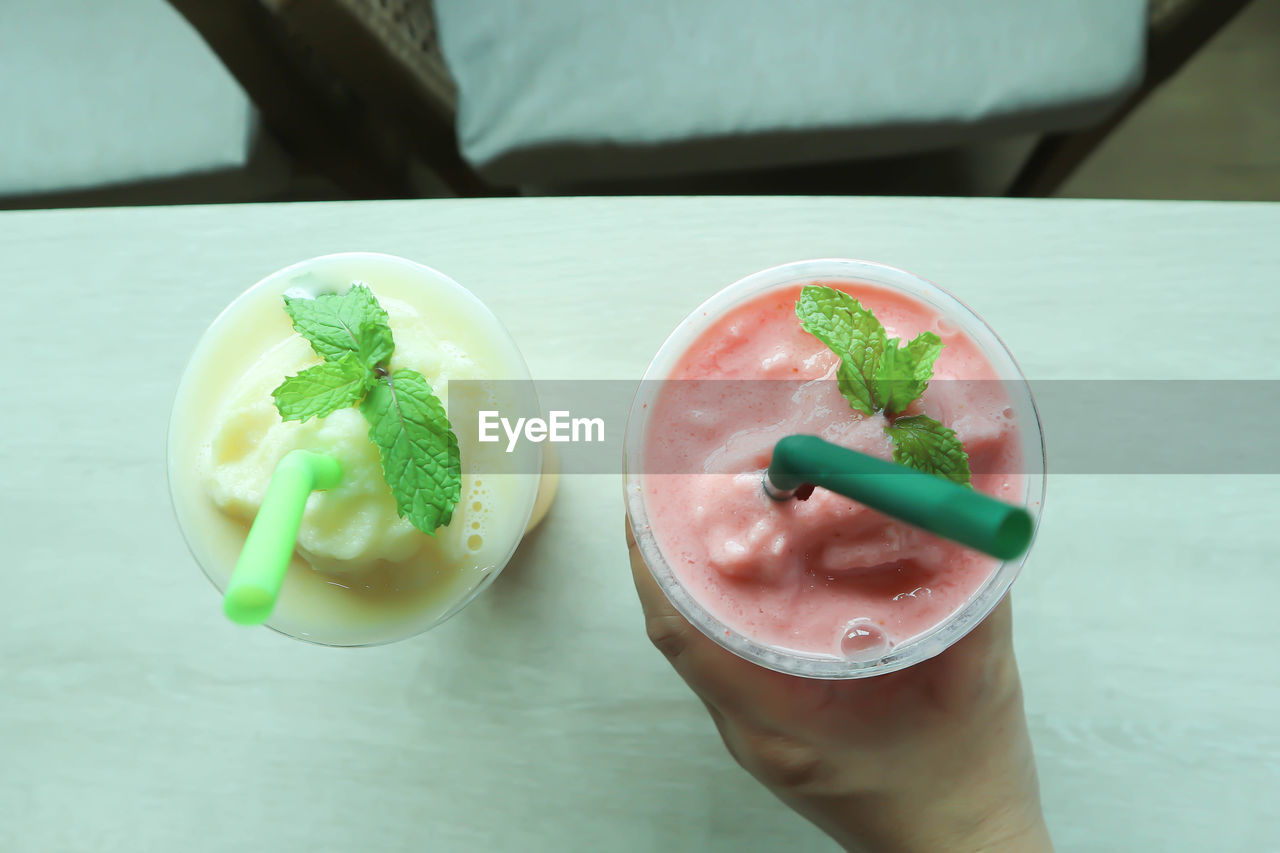 CLOSE-UP OF HAND HOLDING ICE CREAM WITH FRUITS