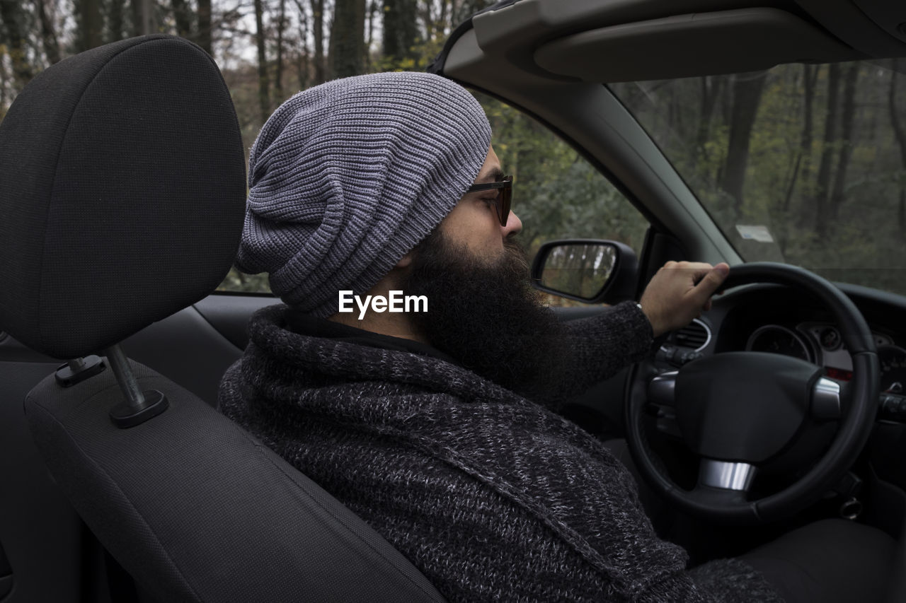 Man wearing knit hat sitting in car