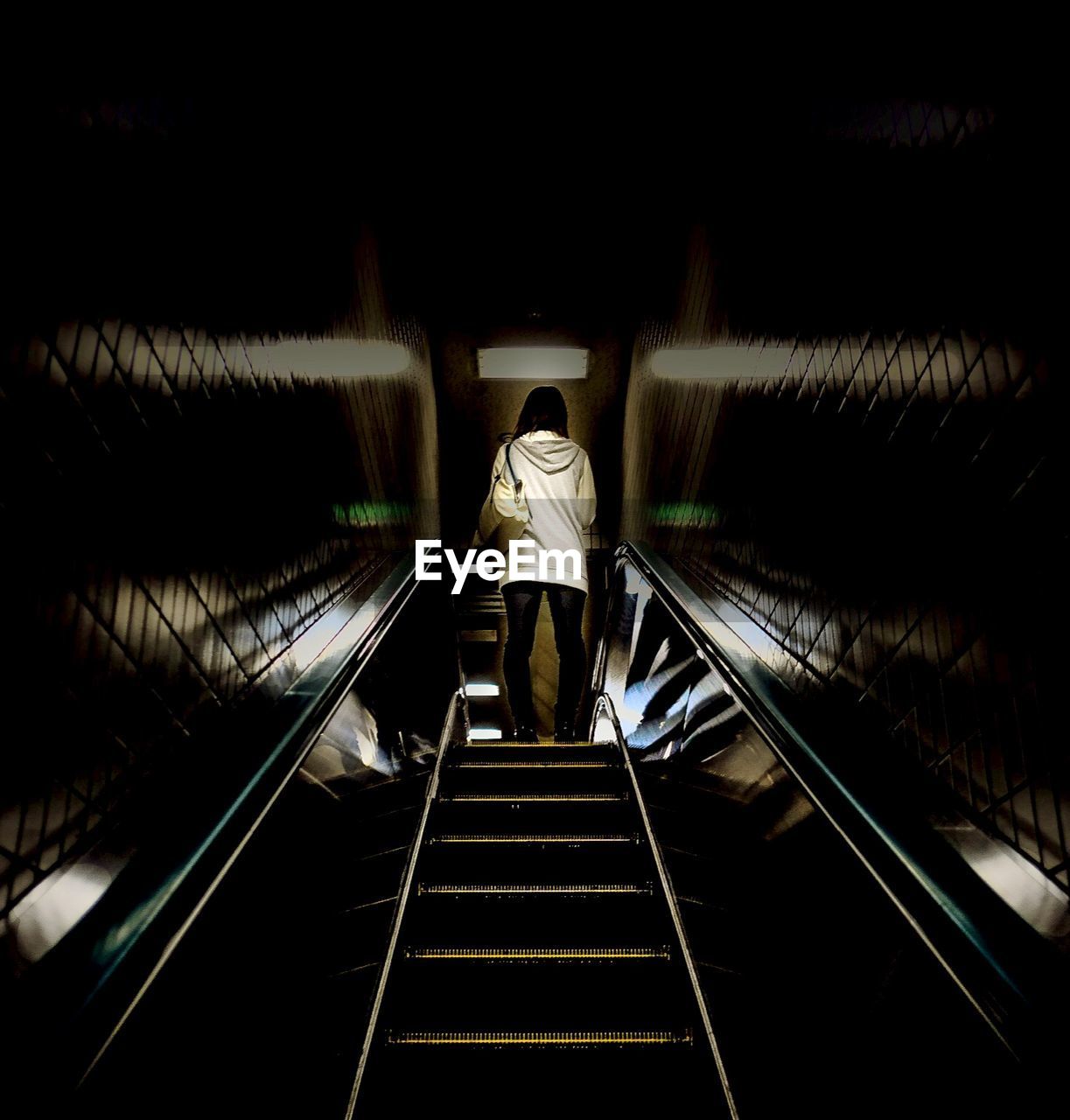 Low angle view of woman standing on escalator
