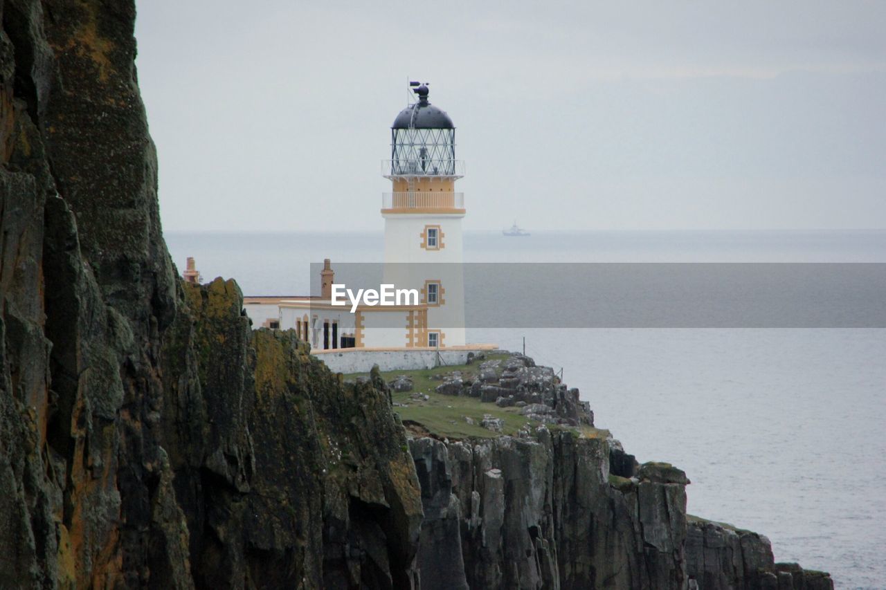 Neist point lighthouse on cliff in sea at isle of skye