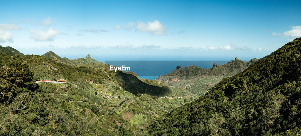 Scenic view of sea and mountains against sky