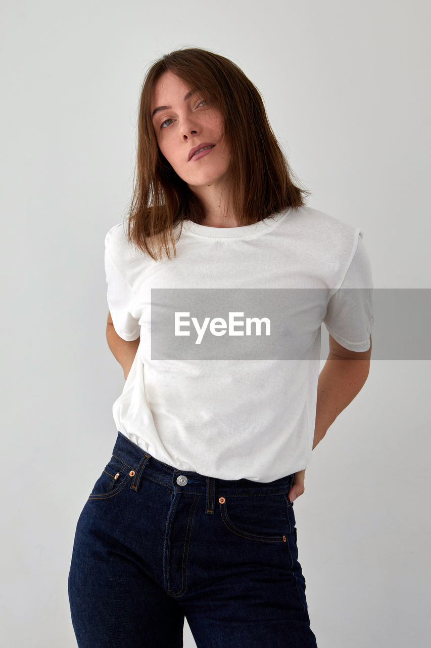 Smiling woman in casual outfit standing in studio