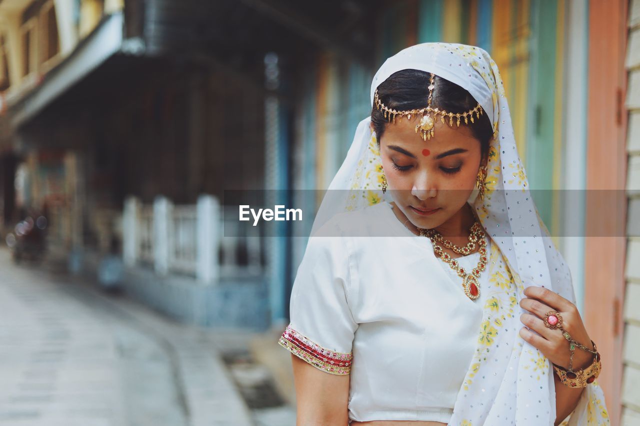 Portrait of young woman standing in city