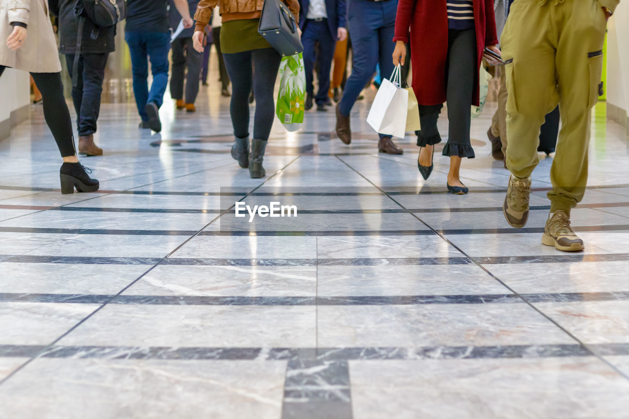 group of people, walking, low section, women, human leg, crowd, architecture, motion, adult, city, men, large group of people, lifestyles, human limb, day, city life, on the move, limb, footpath, group, outdoors, shoe, clothing, street, togetherness, casual clothing, blurred motion, flooring, spring, jeans