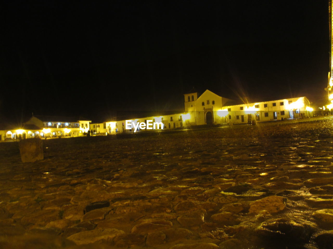 ILLUMINATED HOUSES BY SEA AGAINST SKY