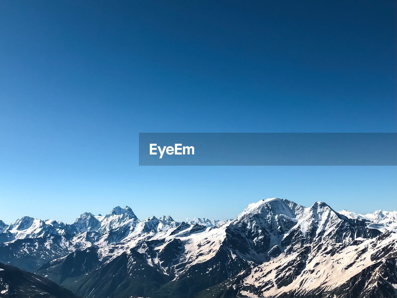 Snowcapped mountains against clear blue sky