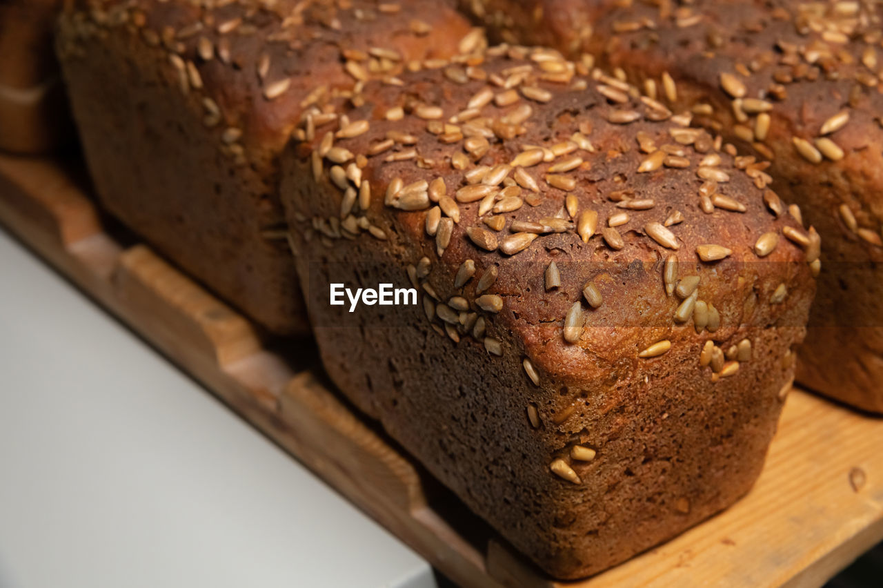 Fresh brown loaves of rye bread in the form of bricks with sunflower seeds on a crust. 