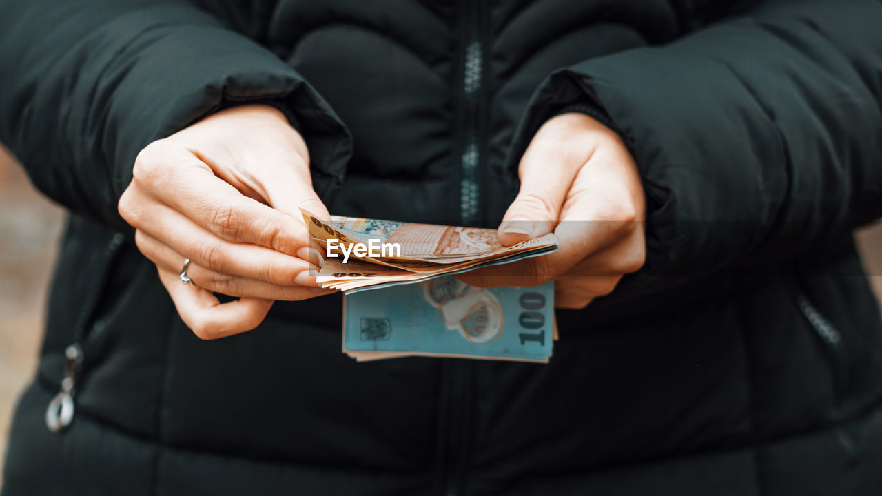 midsection of man holding paper currencies