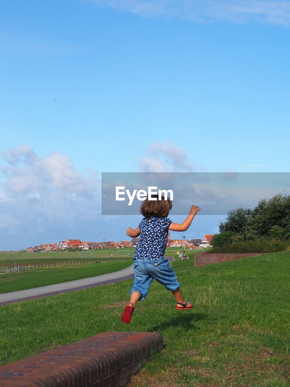 Full length of girl jumping over field