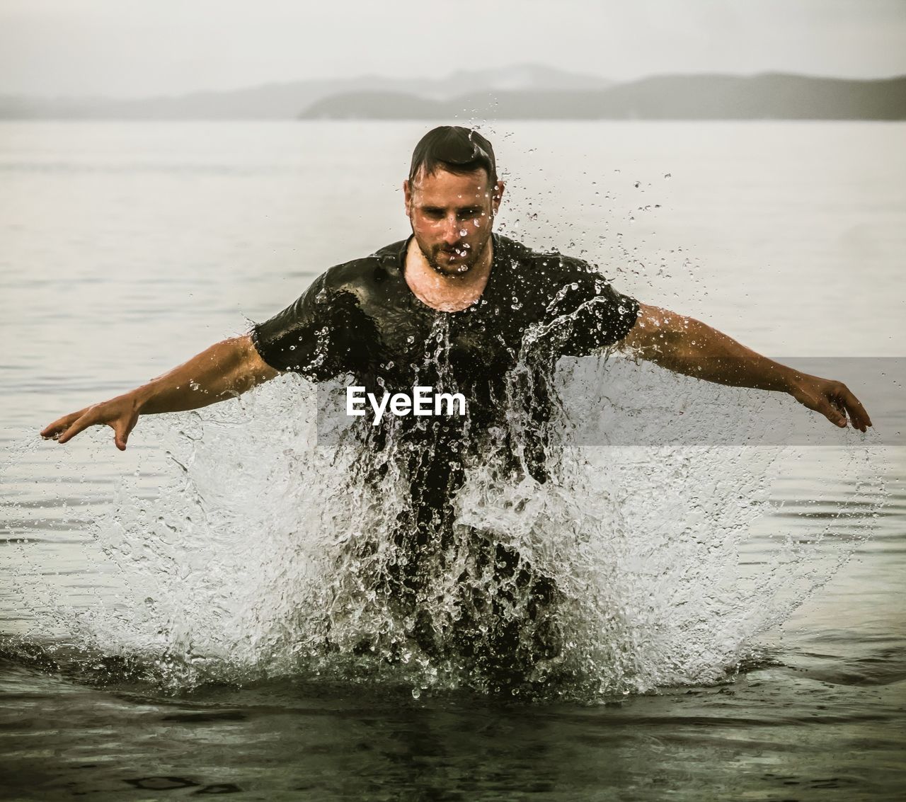 Young man splashing water in sea