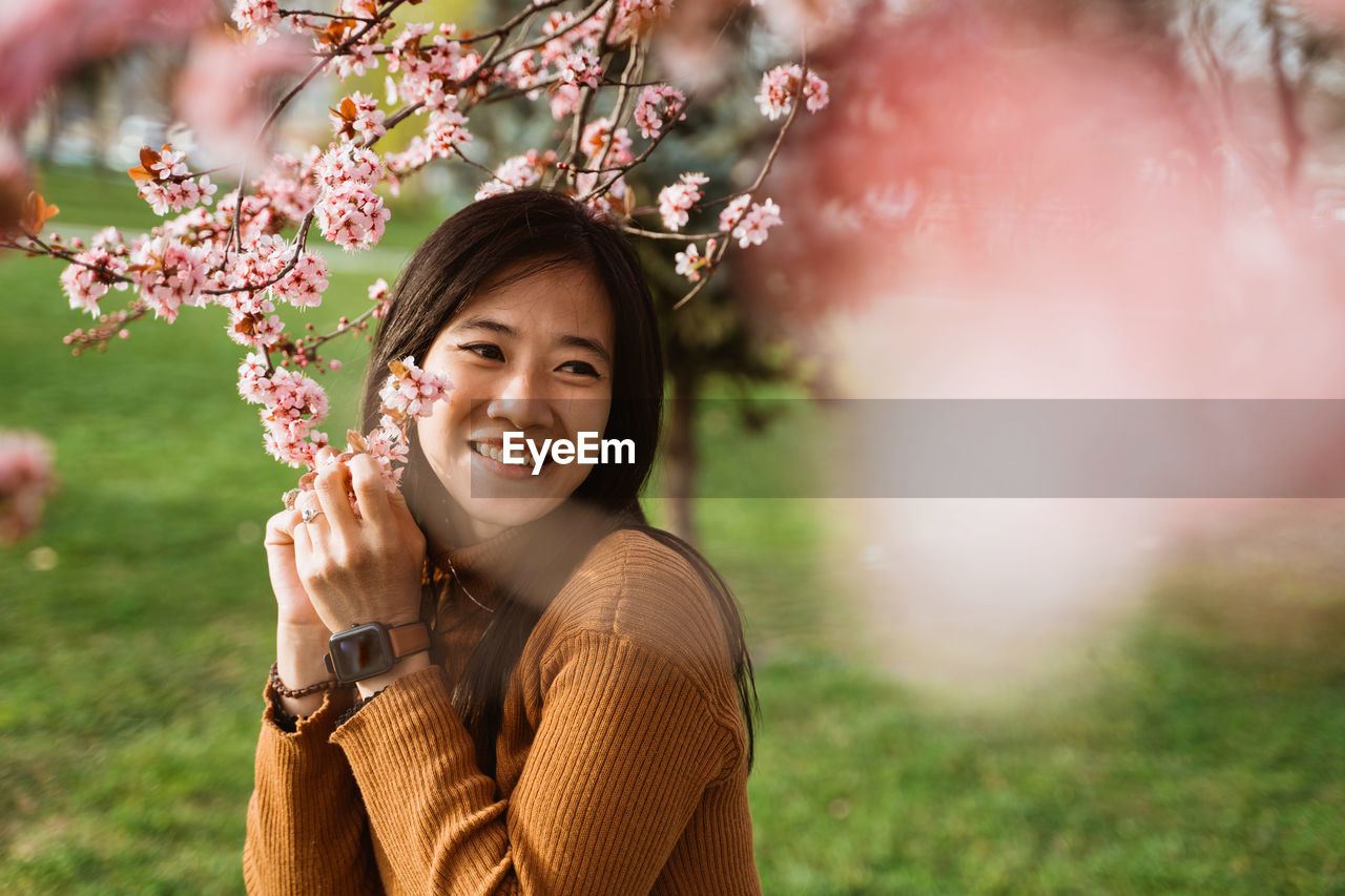 portrait of young woman standing by plants