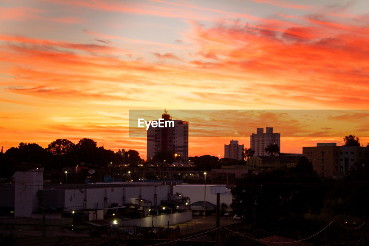 HIGH ANGLE VIEW OF ILLUMINATED BUILDINGS AGAINST ROMANTIC SKY