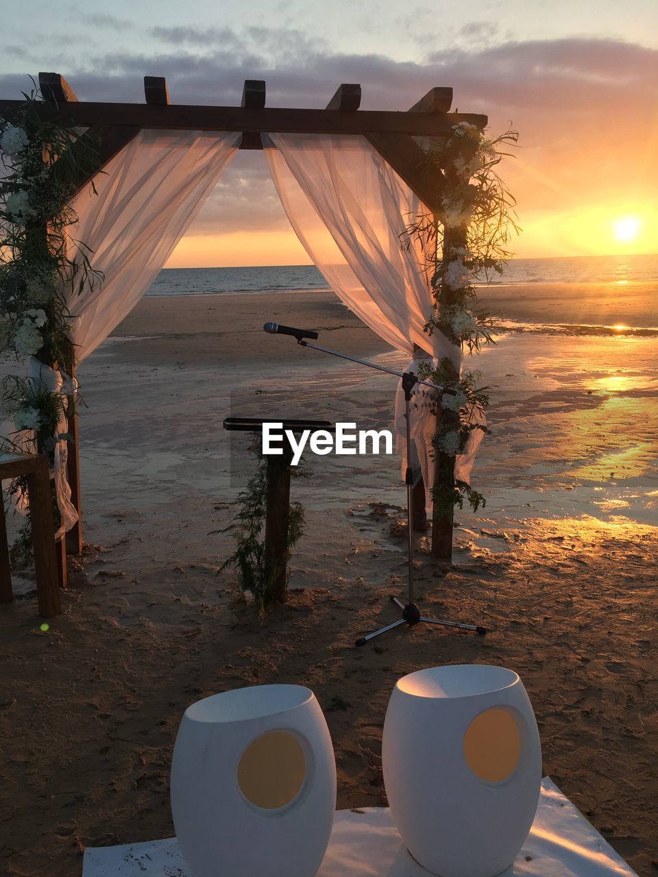 Wedding decoration at beach against sky during sunset