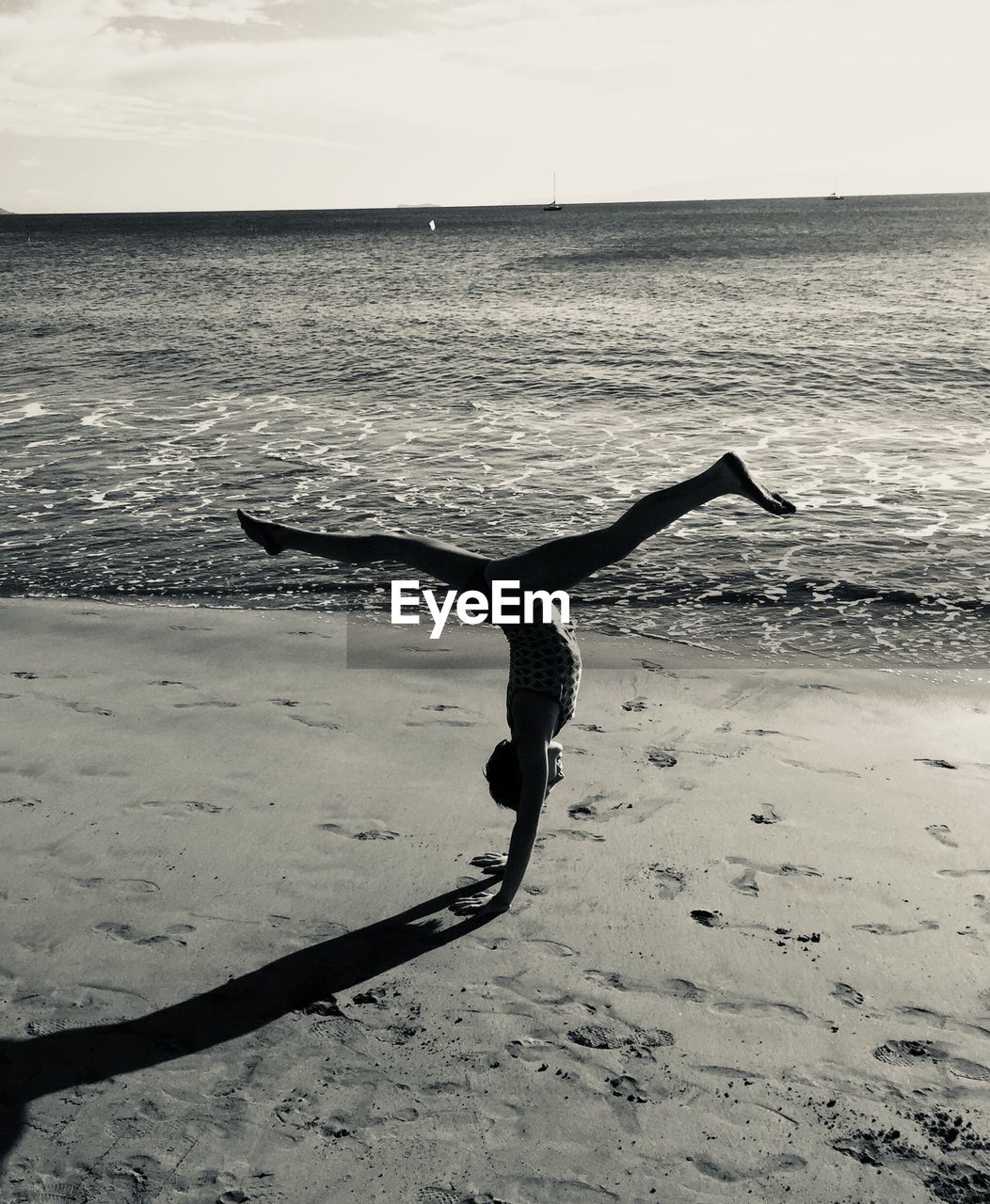 Girl practicing handstand at beach