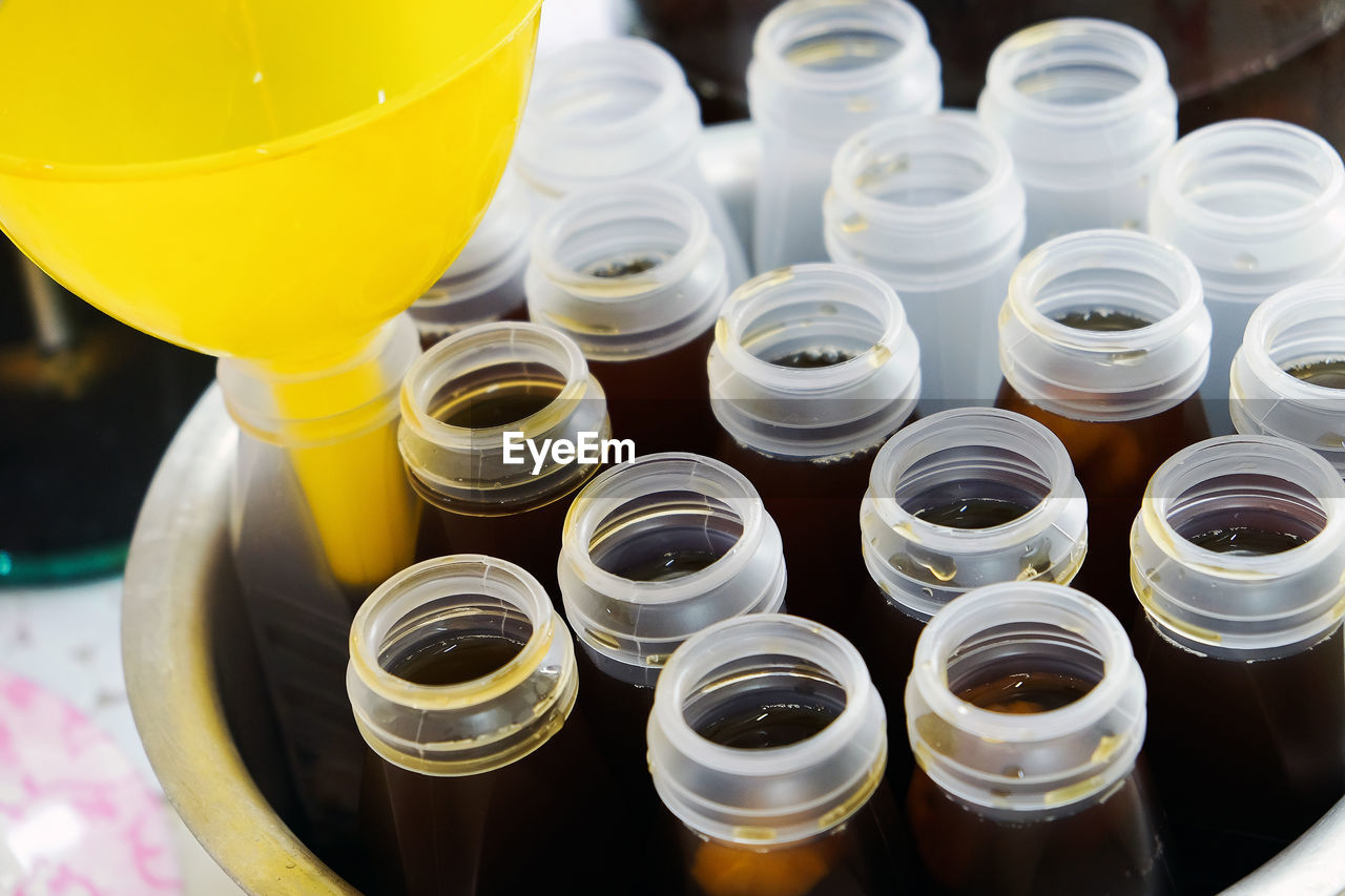 HIGH ANGLE VIEW OF BOTTLES IN GLASS ON TABLE