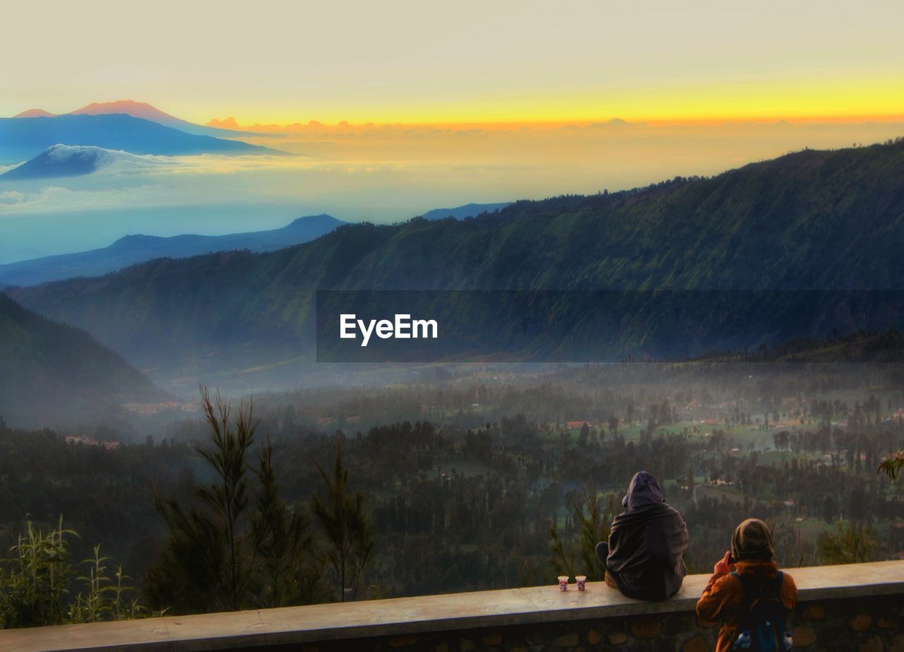 People against mountains during sunset