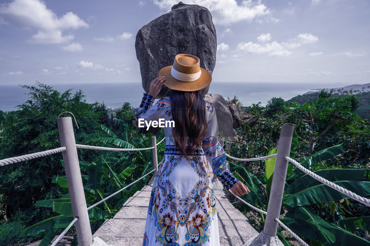 Asian woman tourist sightseeing and enjoying the view of overlap stone at samui island in thailand,