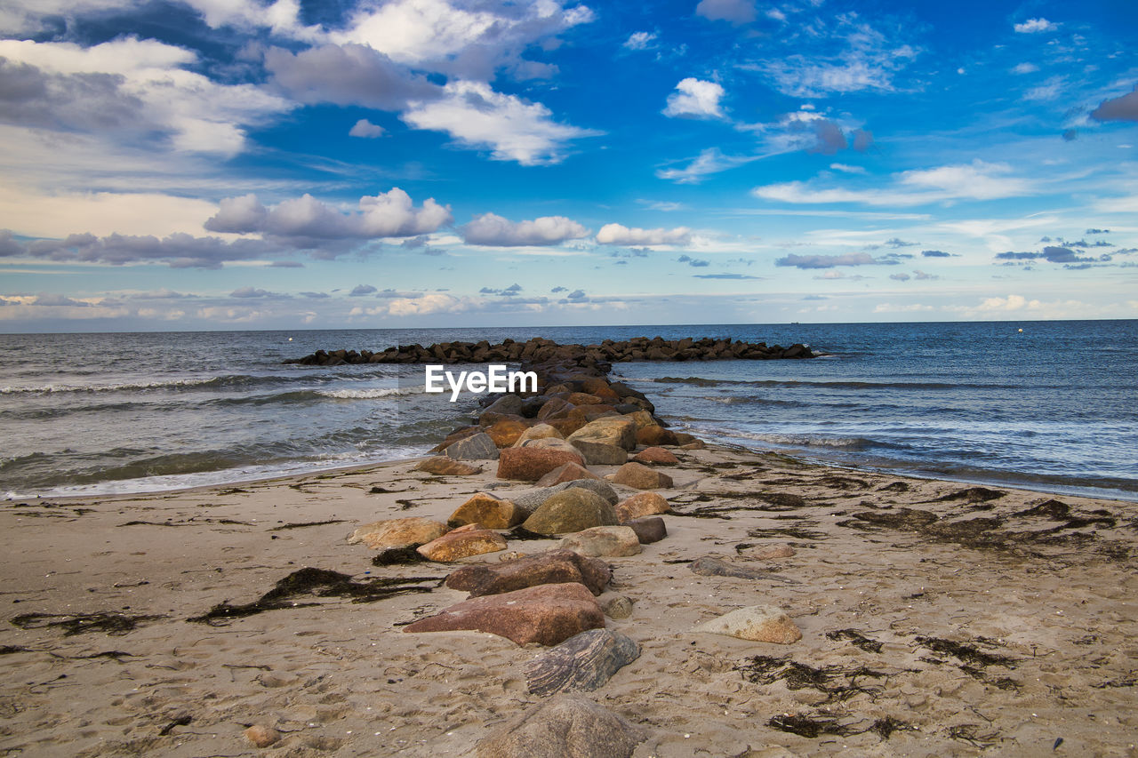 SCENIC VIEW OF ROCKS ON BEACH AGAINST SKY
