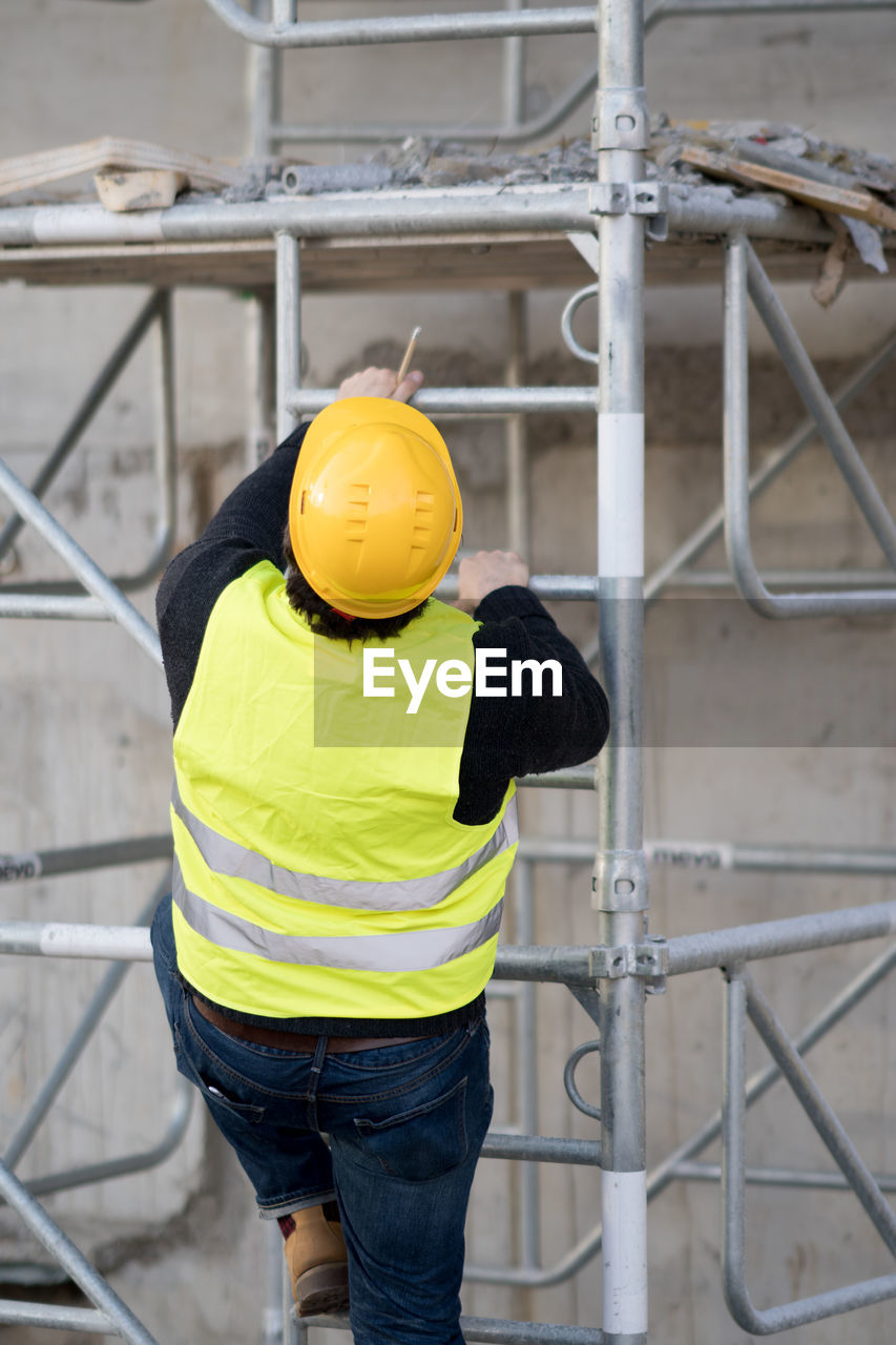 Construction worker climbing on scaffolding