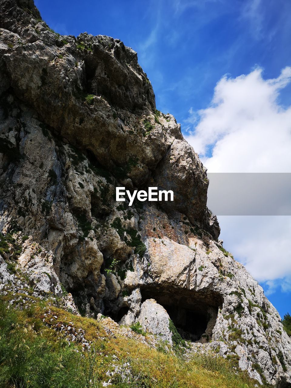 LOW ANGLE VIEW OF ROCK FORMATION AND TREE AGAINST SKY