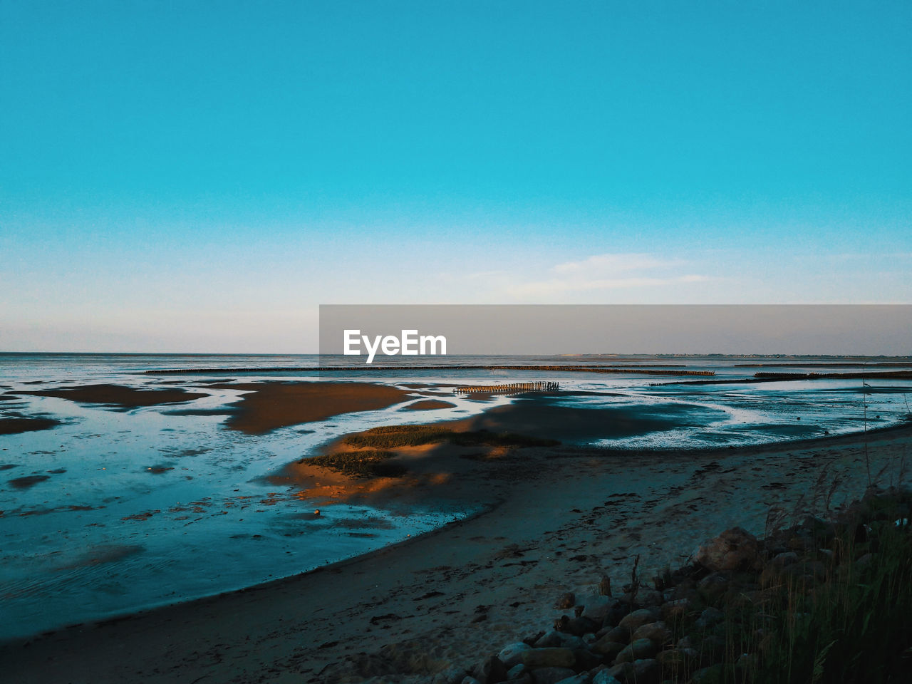 Scenic view of beach against blue sky