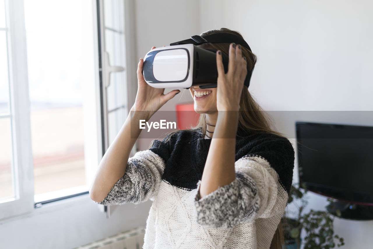 Young woman wearing vr glasses at home