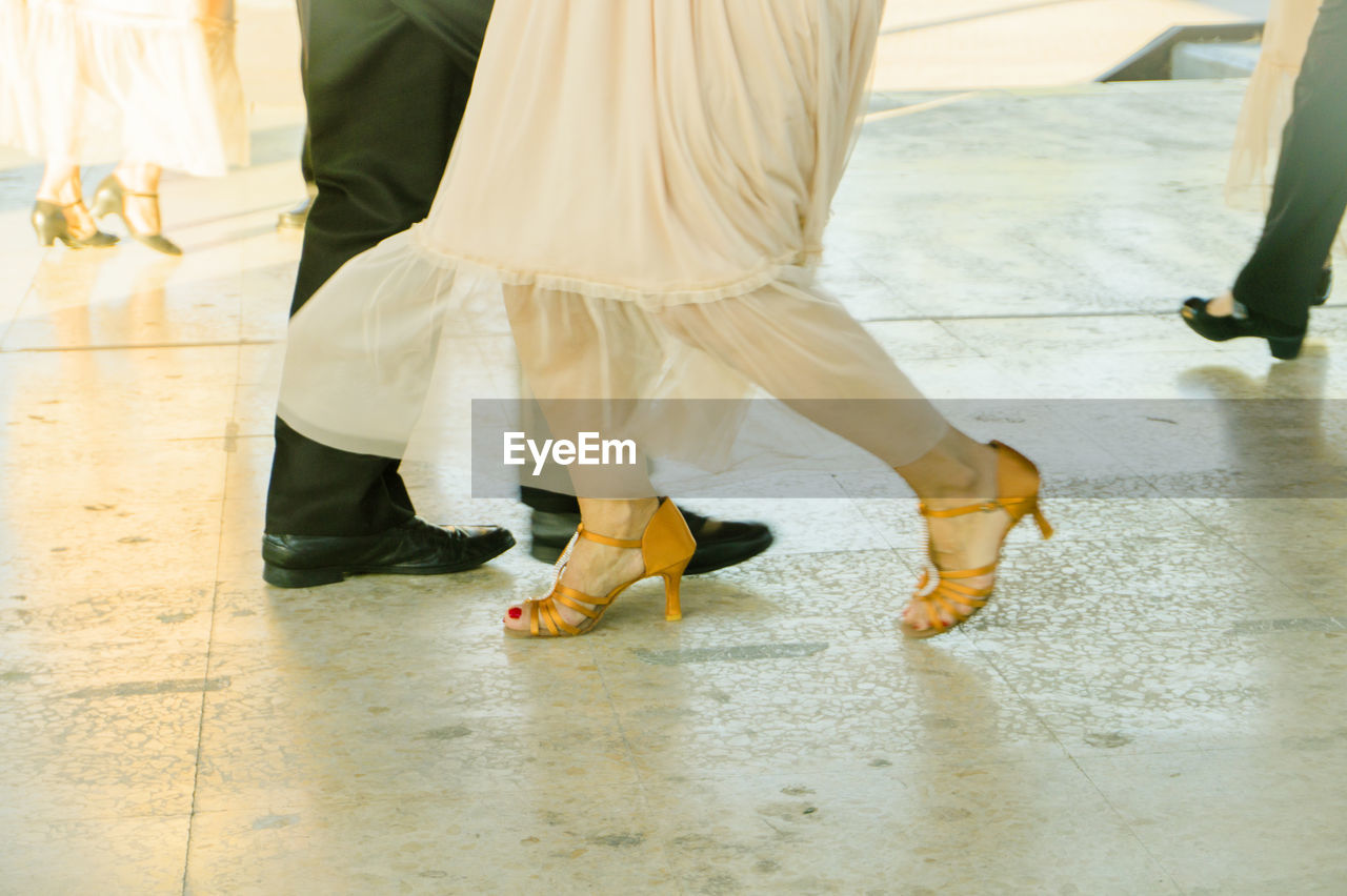 Low section of man and woman dancing on floor