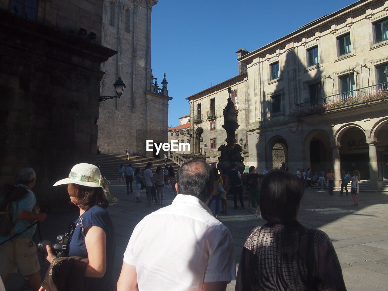 REAR VIEW OF PEOPLE ON STREET AGAINST BUILDINGS