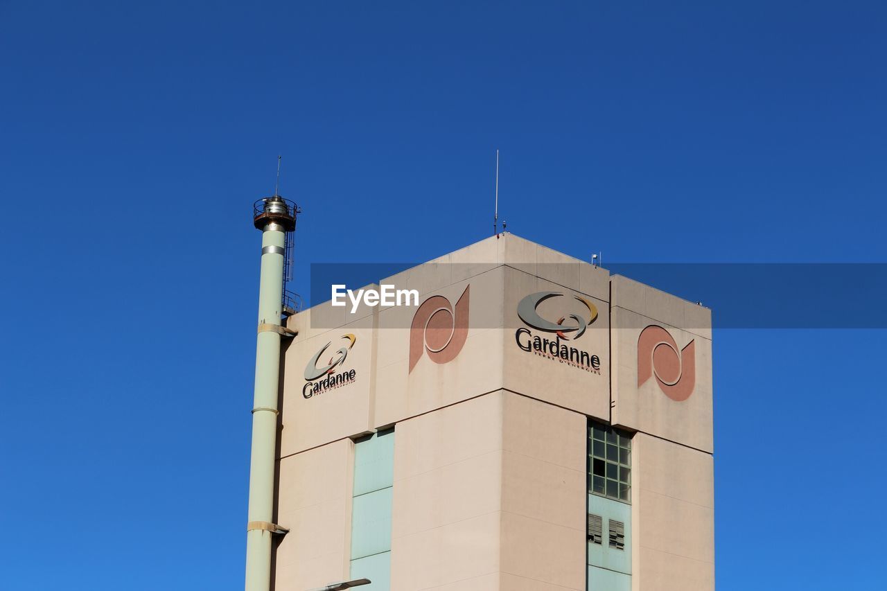 LOW ANGLE VIEW OF CLOCK TOWER AGAINST BUILDING