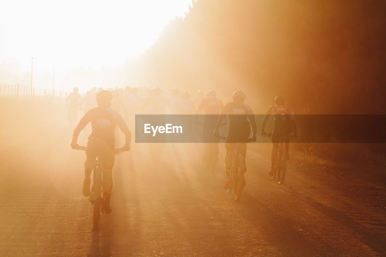 Cyclists against sky during sunset