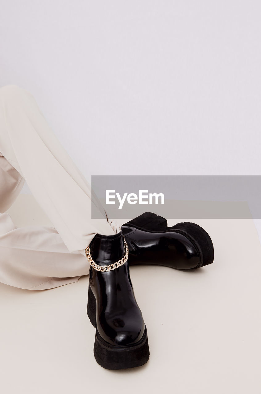 Details of trendy casual fall spring outfit. woman wearing white jeans and black platform boots.
