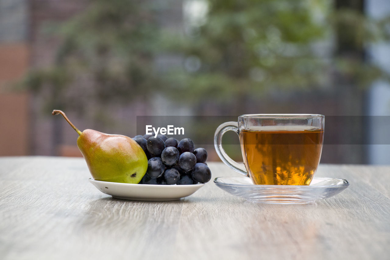 CLOSE-UP OF FRUITS SERVED WITH DRINK ON TABLE