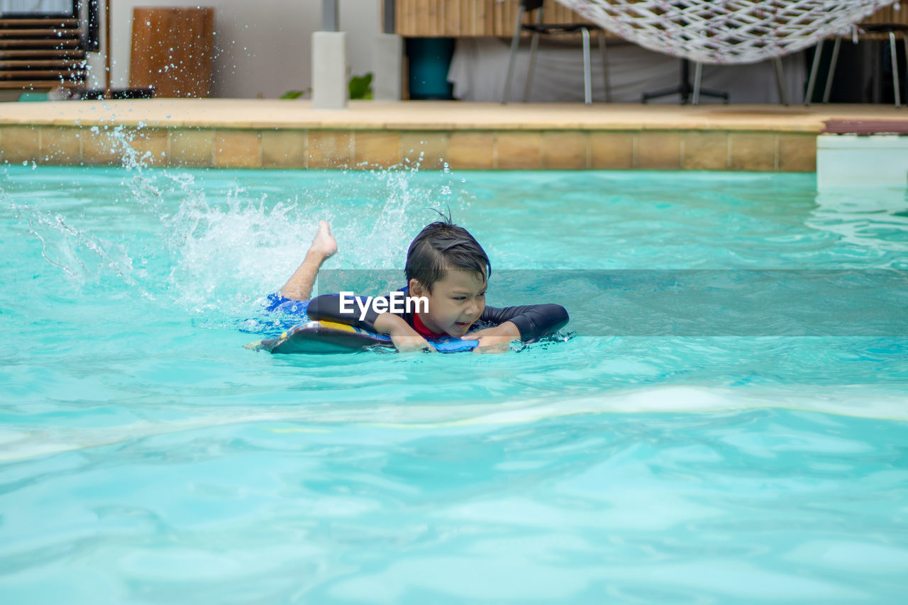 Full length of boy swimming in pool