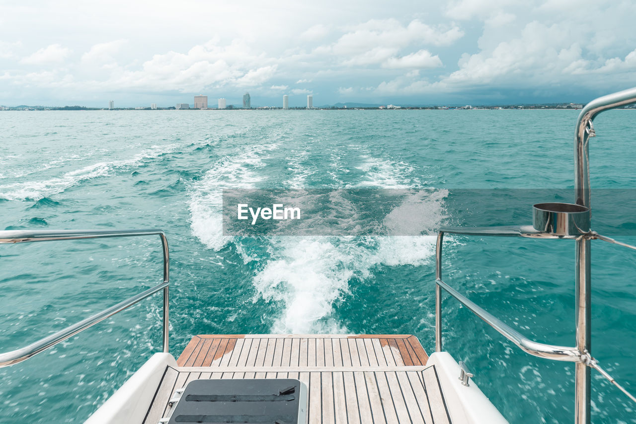 Sea wave from catamaran yacht engine with pattaya beach and sky in the background. 