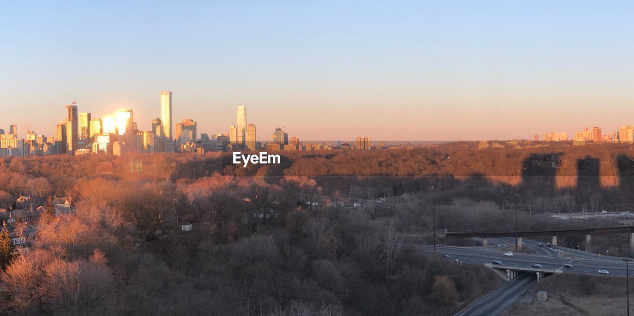 PANORAMIC SHOT OF BUILDINGS AGAINST CLEAR SKY DURING SUNSET