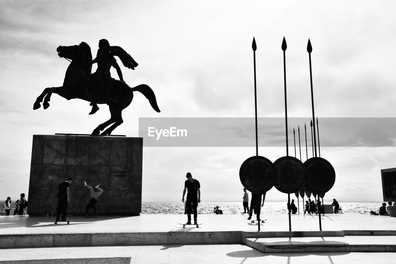 STATUE AGAINST PEOPLE IN SKY