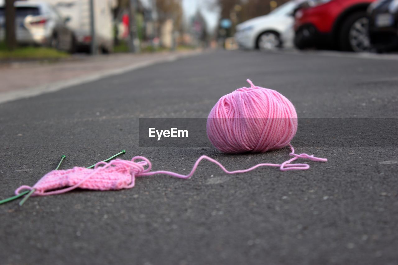 Close-up of pink knitting wool on road